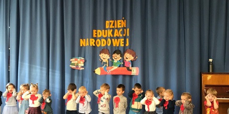Powiększ grafikę: Grupa "Biedronek" śpiewa i pokazuje piosenkę na występie z okazji Dnia Edukacji Narodowej.