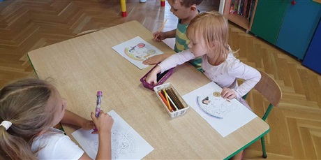 Powiększ grafikę: Dzieci z grupy 3 kolorują obrazek z osobami na wózku inwalidzkim.