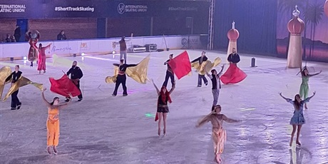 Powiększ grafikę: Grupa artystów tańczy na lodowisku.