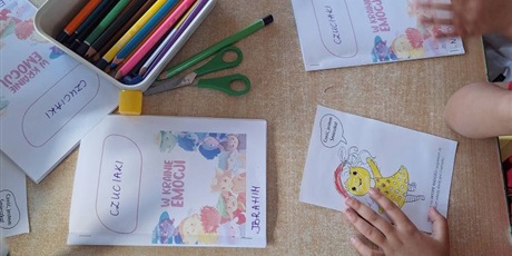 Powiększ grafikę: Na stole leżą książeczki zrobione dla dzieci z napisem Czuciaki w krainie emocji.