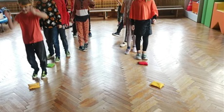 Powiększ grafikę: Dzieci z grupy IV ćwiczą z woreczkami na sali gimnastycznej.