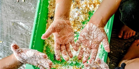 Powiększ grafikę: Dłonie dzieci ubrudzone mąką i kawałkami warzyw.